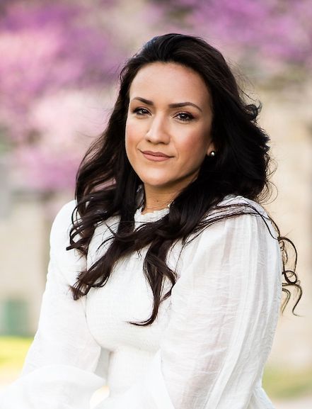 High school senior photographer Kansas City, Christiana J, Portrait in classic white top with spring blossoms creating soft bokeh effect.