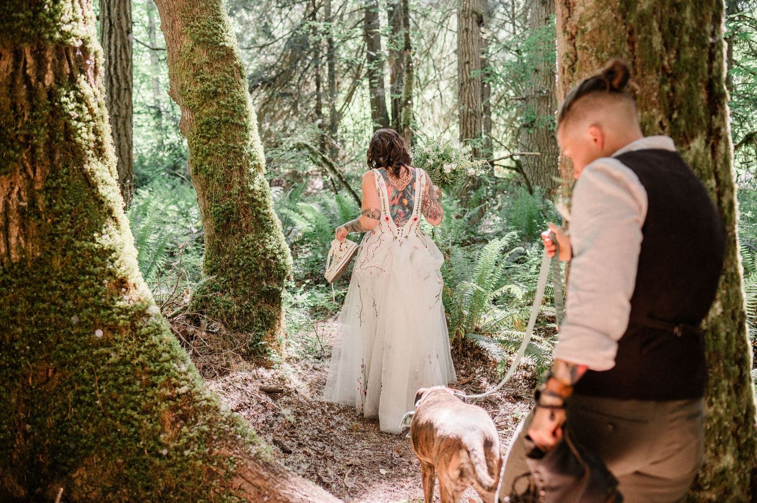 couple walking through woods on their wedding day. Photo by Washington Elopement Photographer