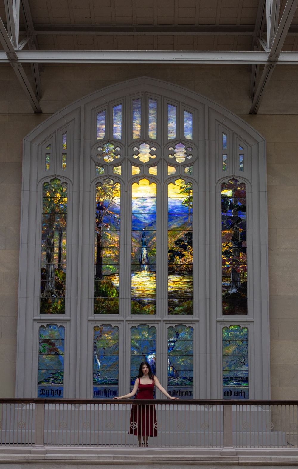 Stained glass windows in an ornate church or chapel feature vibrant scenes of nature and landscapes.