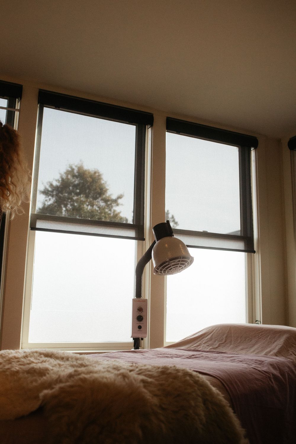 Interior photograph of the acupuncturist studio with soft pastel linens and a heat lamp in downtown Portland, Maine.