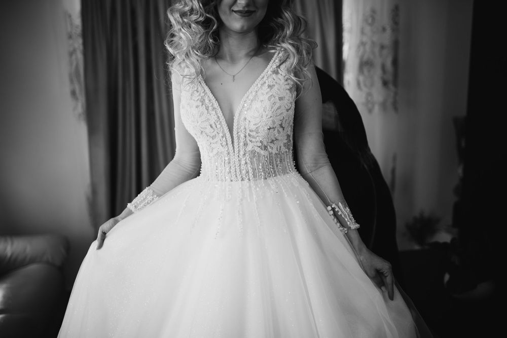Black and white portrait of bride in elegant lace ball gown wedding dress.