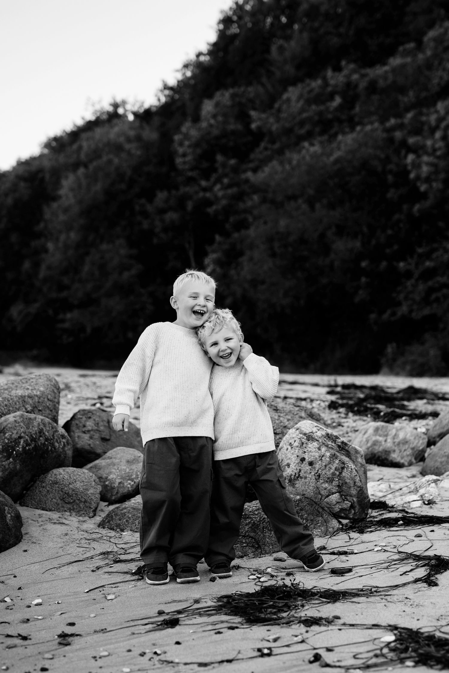 søskende fotograferes på stranden. sjov og ballade på stranden med fotograf jane søndberg fotografering århus fotograf aarhus