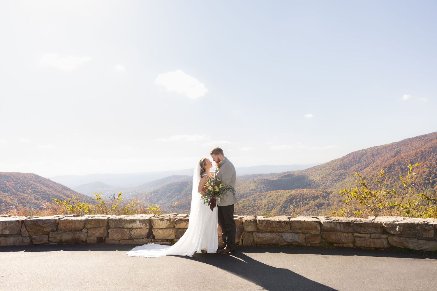 Bride and groom stand at a mountain overlook during their sunrise wedding ceremony in Shenandoah National Park in Virginia.