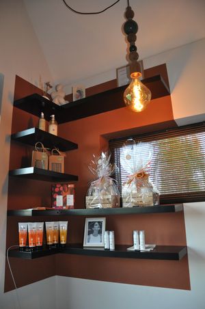 Beauty salon retail shelves displaying skincare products and gift sets with warm pendant lighting.