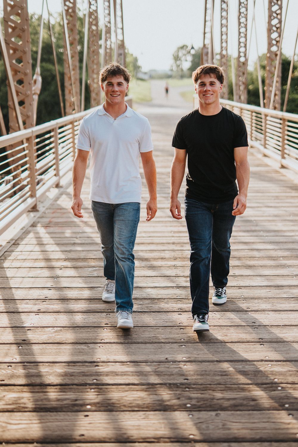 A series of cropped photos showing two people walking together on a wooden boardwalk through trees.