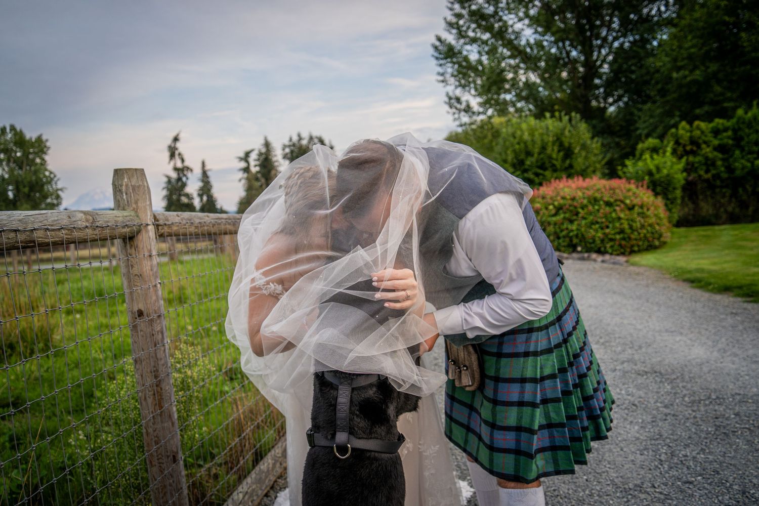 Intimate wedding moment captured on a rustic path with mountain views.