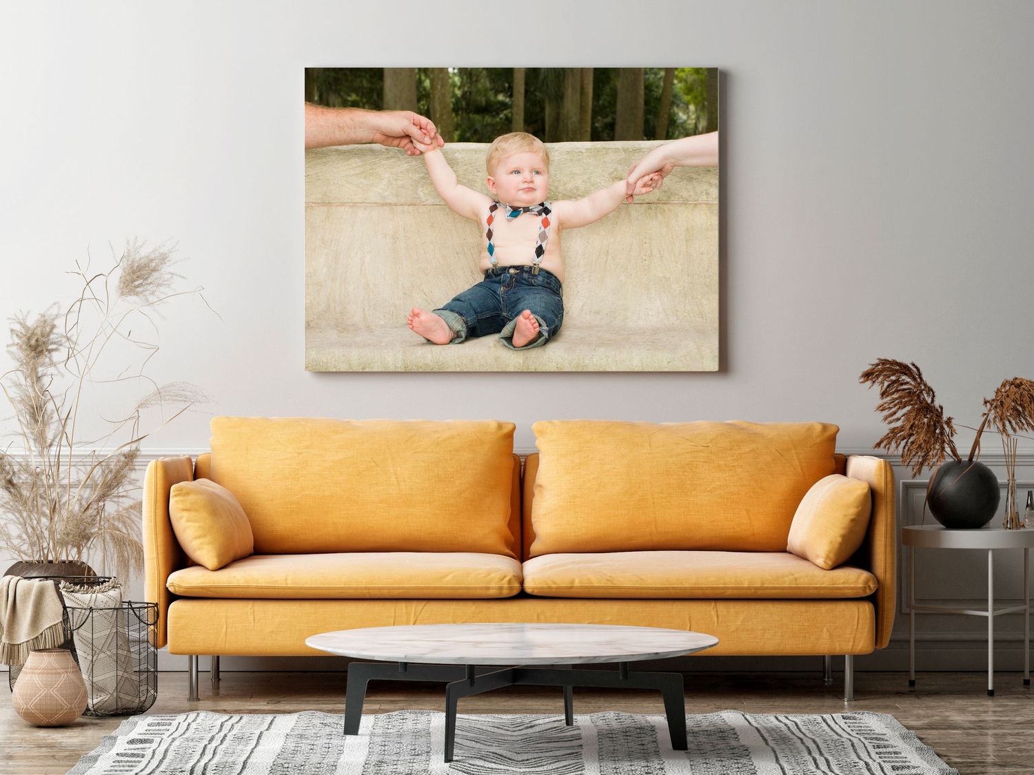 Stylish mustard yellow sofa with decorative wall art and pampas grass accents in a modern living room setting.