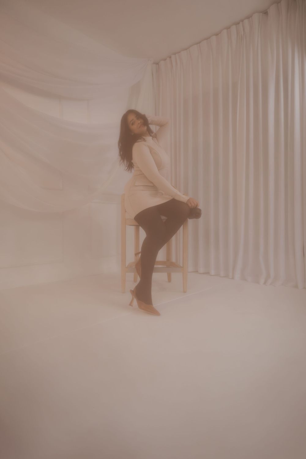 Artistic photo series showing silhouetted figure posing on chair against white curtained backdrop.
