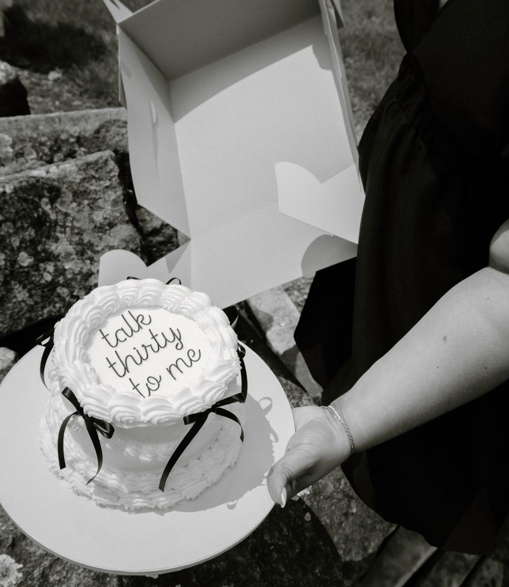 A sequence of black and white images showing hands holding a decorated cake at a celebration.