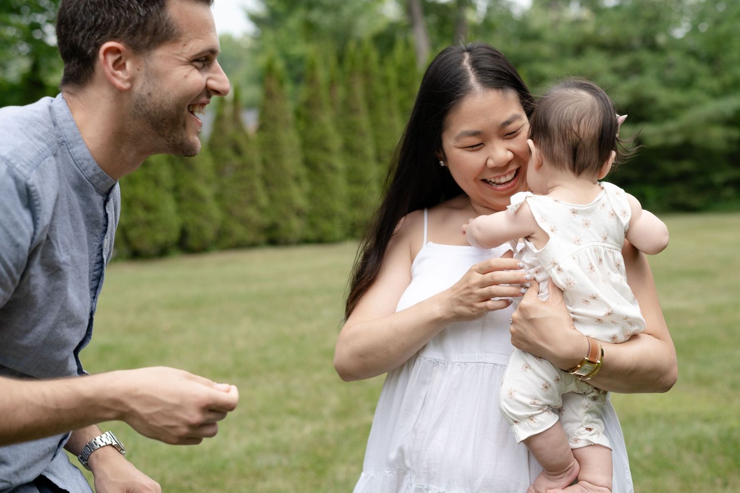 A happy family shares a joyful moment together outdoors in a lush green garden setting.