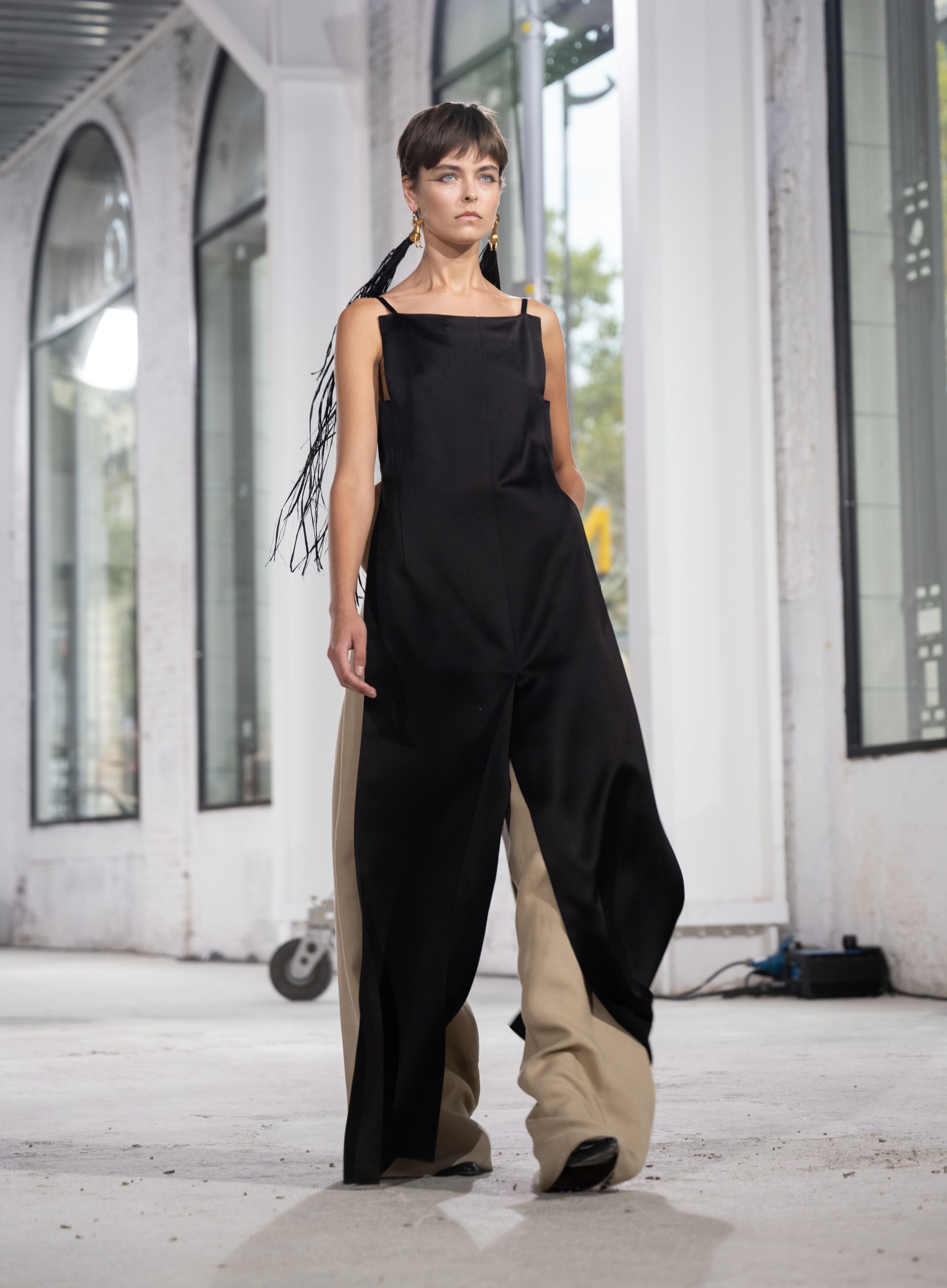 Dramatic black and beige wide-leg jumpsuit shown during fashion week runway presentation.
