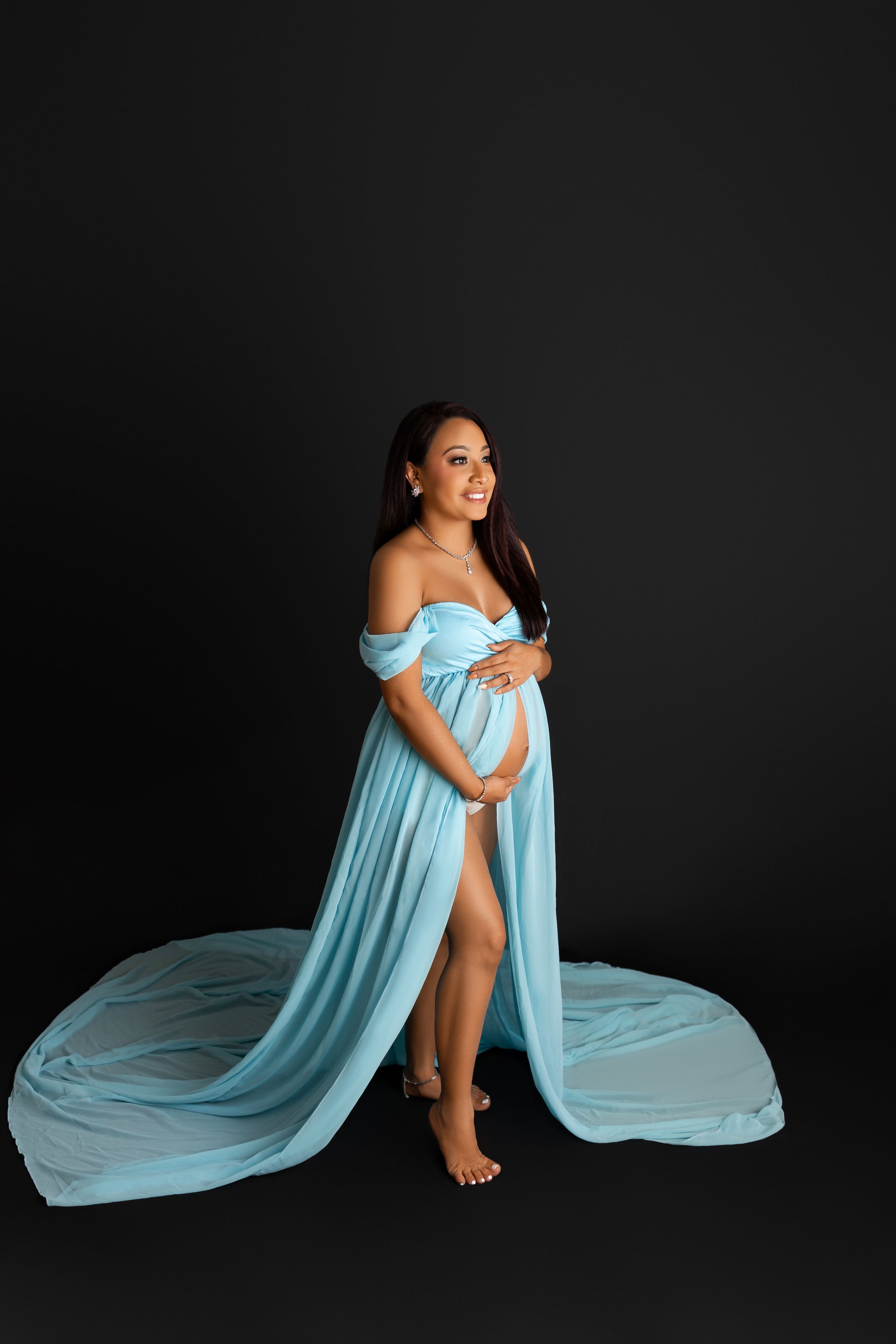 Maternity portrait featuring an elegant light blue flowing dress. Sarah Jane Photography LLC Photographer in Sparta NJ