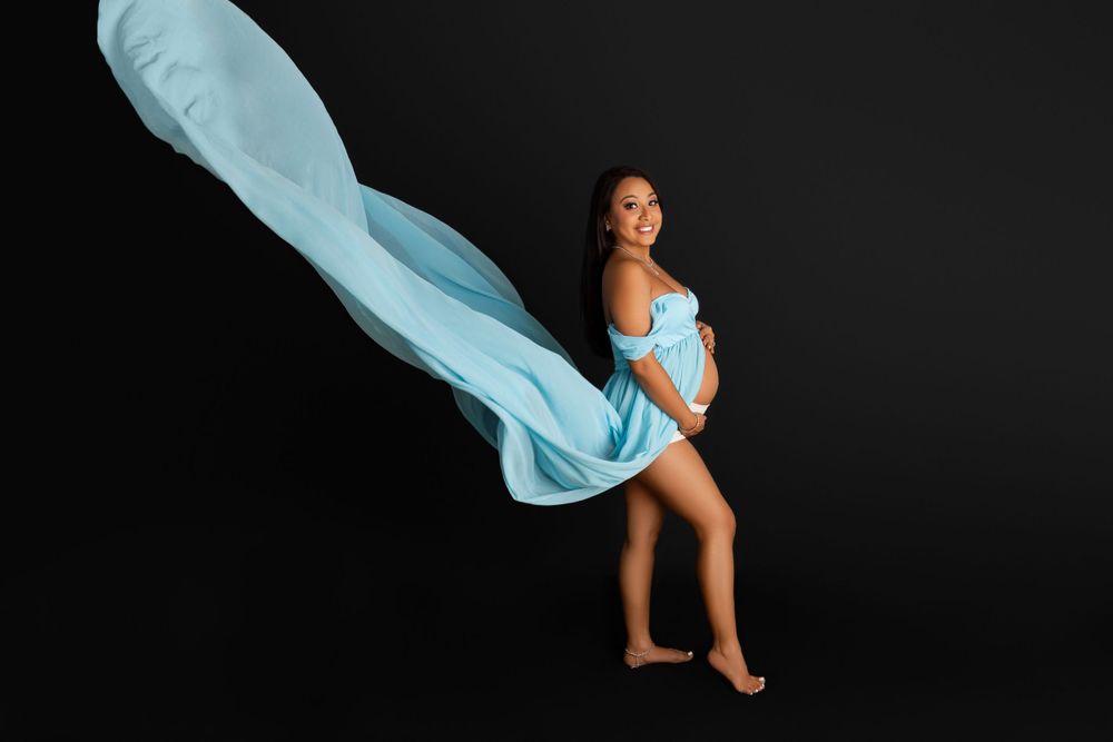 Dancer in light blue flowing fabric performs graceful pose against black background. Sarah Jane Photography LLC Photographer in Sparta NJ