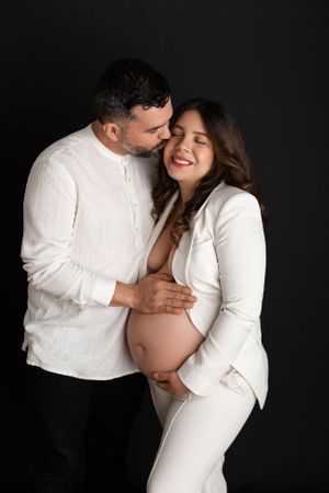 Intimate maternity photo of couple in white clothing. Morris County Studio Maternity Photographer