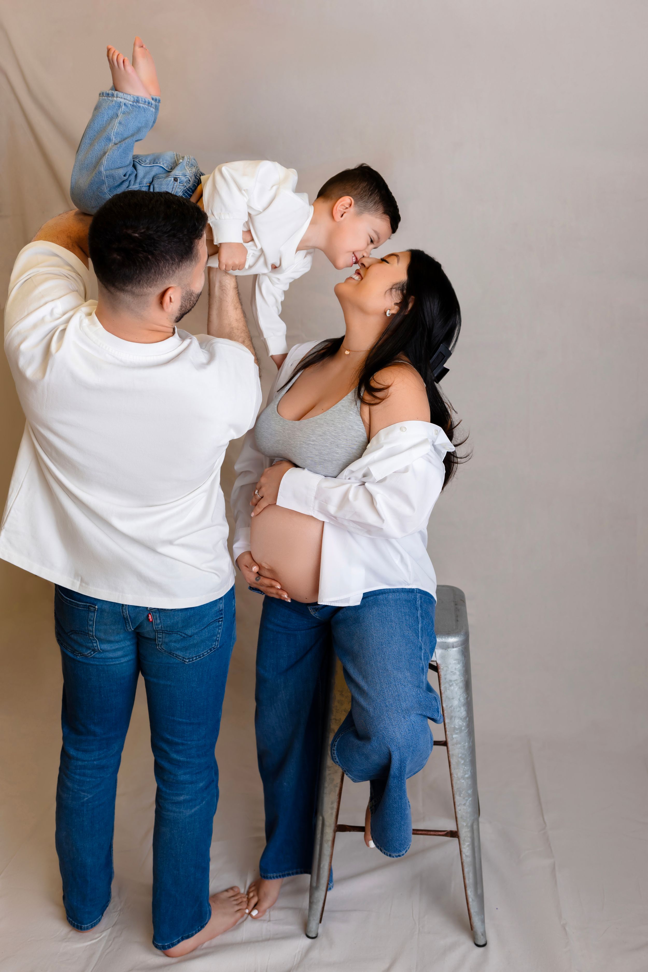 A couple wearing matching white shirts and jeans pose Studio Maternity Photographer in NJ | Sussex County NJ