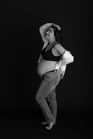 Black and white maternity portrait of an expectant mother in jeans. Studio Maternity Session in Morris County New Jersey