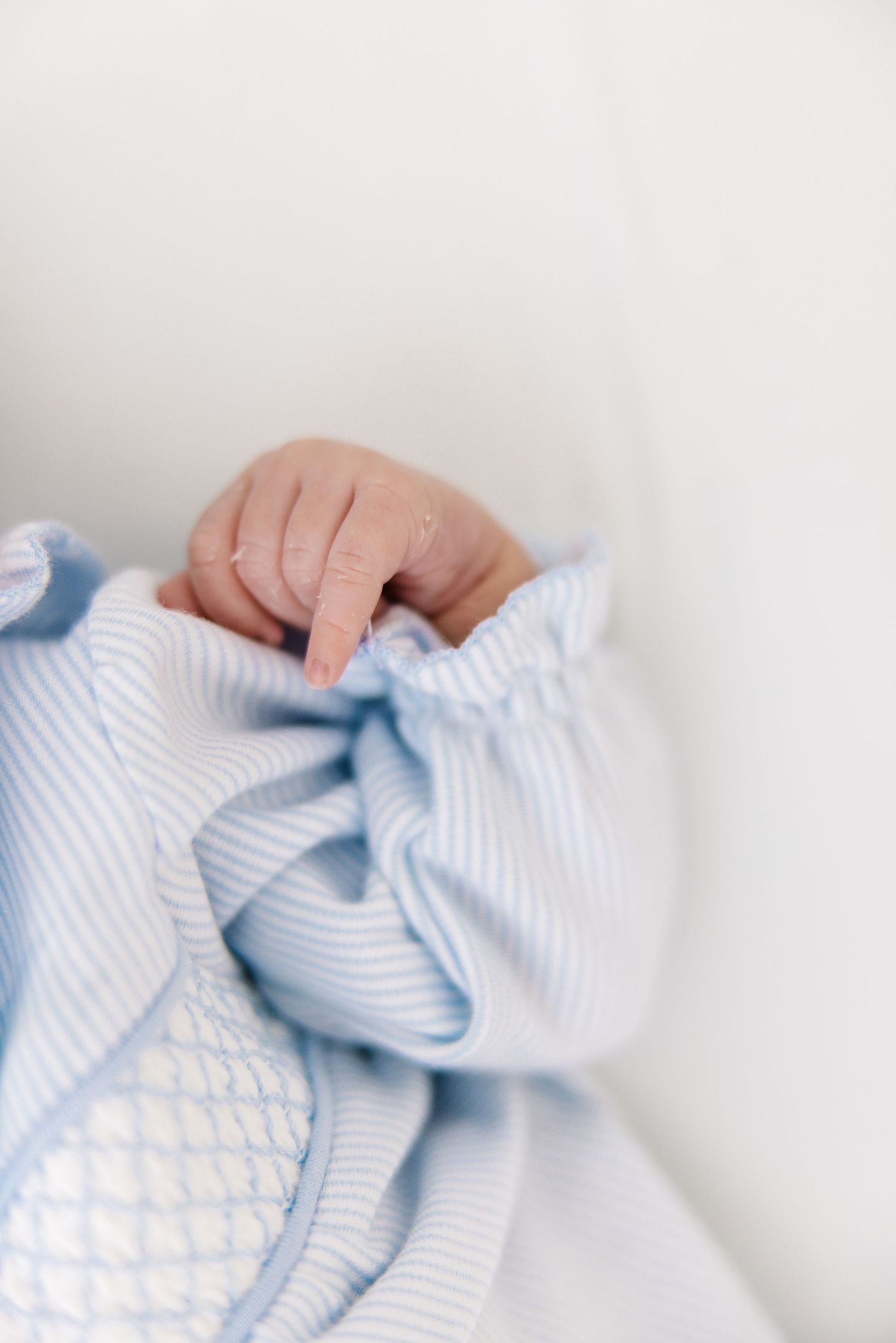 Close-up series of blue and white striped fabric being gently handled against white background.