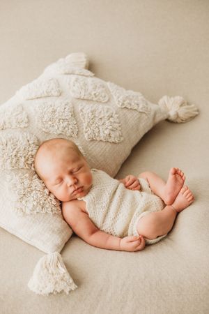 newborn baby asleep on a cushion captured at home in Hertfordshire by Sarah Shaw Photography