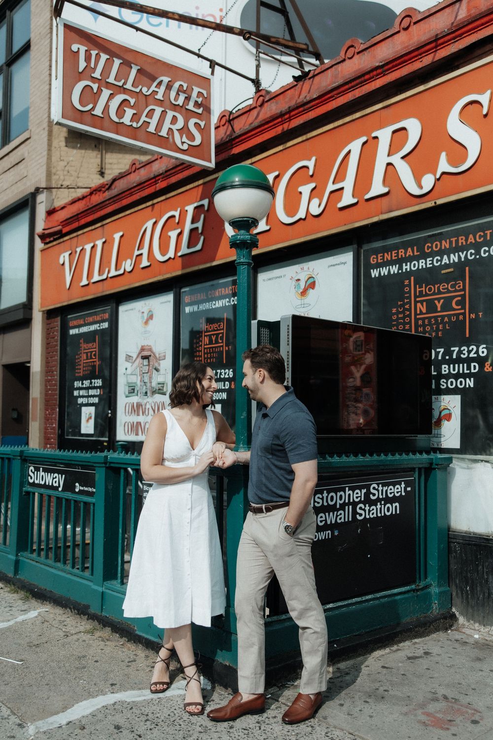 A couple shares a moment outside Village Cigars storefront in New York City.