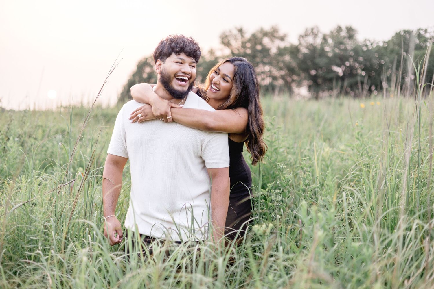 Romantic couples photoshoot in a tall grass field at sunset.