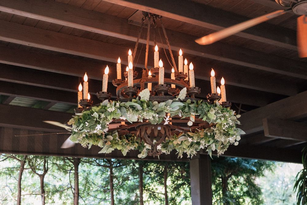 Reception space at The Raymond 1886 with string lights and wooden tables.