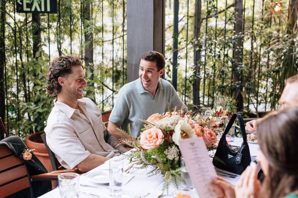 Couple greeting guests at outdoor patio reception.