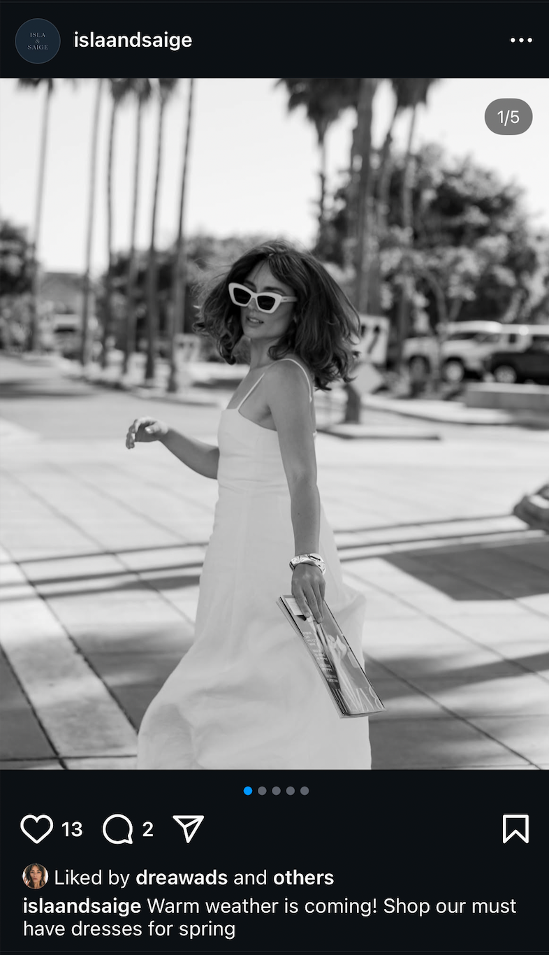 A person poses outdoors in a flowy white sundress with palm trees visible in the sunny background.