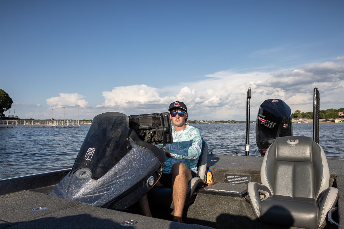 View from inside a bass boat showing the control console and seats on a sunny afternoon.