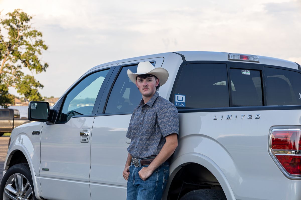 A person stands beside a silver Ford F-150 Limited pickup truck in an outdoor setting.
