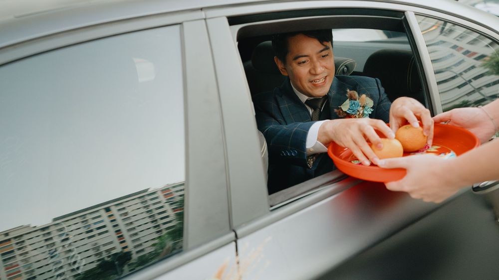 A client in a car paying for fast food at a drive-thru window using a card payment system.