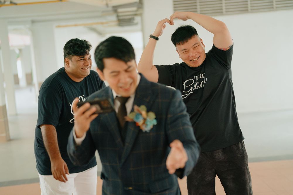 A group of people dressed in black attire laughing and posing casually in a bright indoor space.