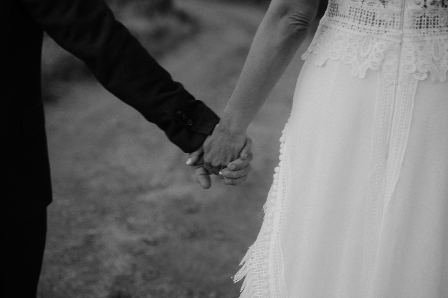 An artistic photo of a bride and groom holding hands after their wedding in Greece