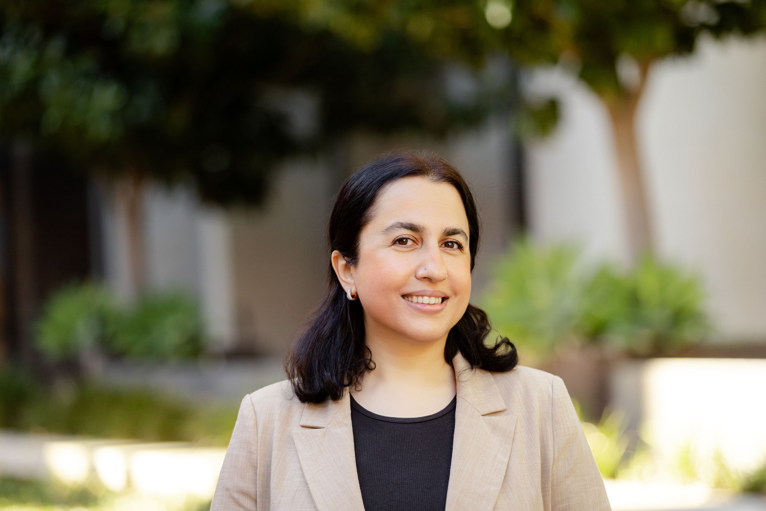 Professional headshots showing smiling faces against a blurred outdoor background.