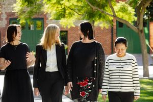 Staff members gathered outdoors for a group photograph wearing business attire.