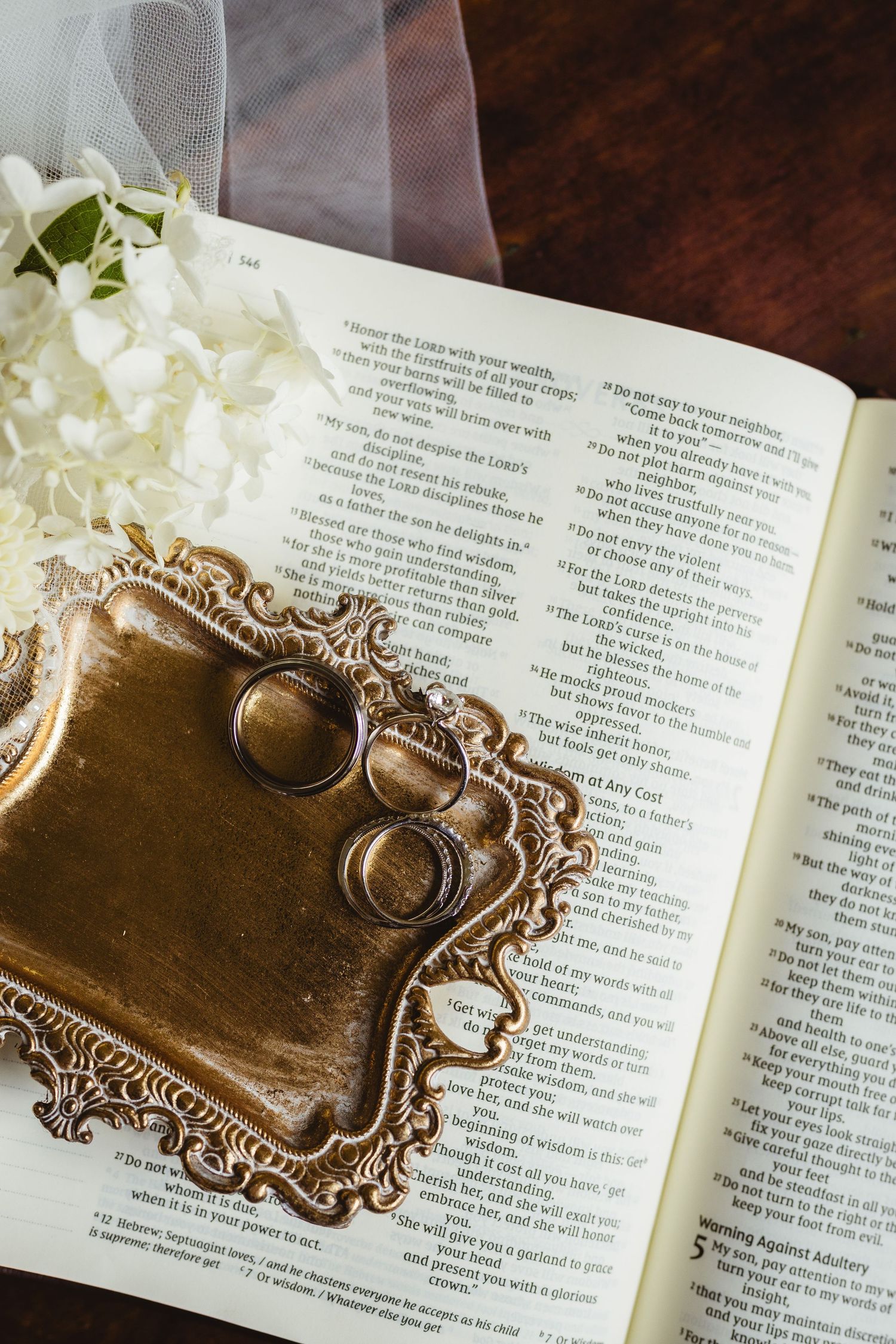 Ornate gold ring holder with vintage design displayed on open book pages.