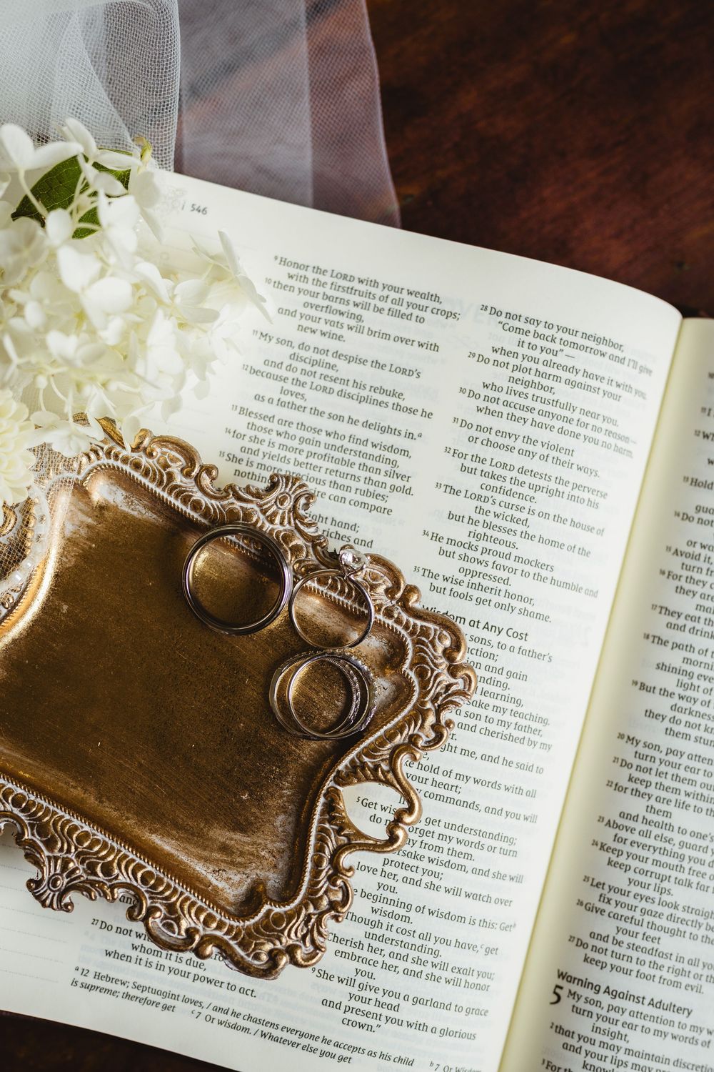 Ornate gold ring holder with vintage design displayed on open book pages.
