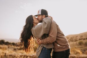 A series of romantic desert photos showing a couple embracing at sunset in warm golden light. Queer wedding photographer New Mexico.