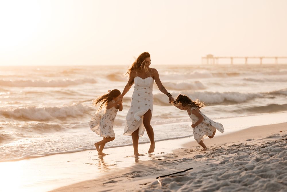 Candid Family photographer in Destin Florida captures mother and daughter fun moments on the beach during sunset. Highly rated and friendly