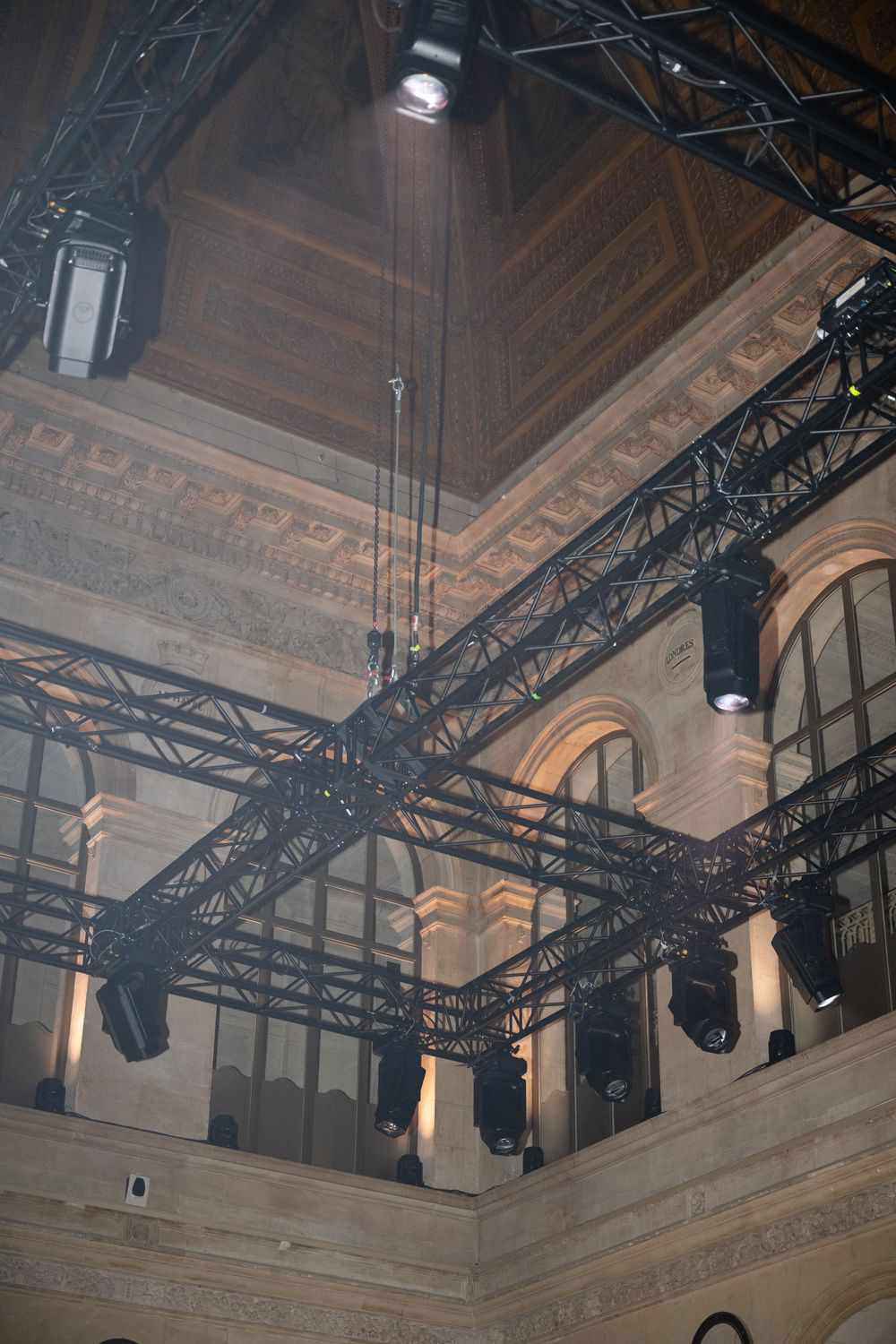 Ornate theater ceiling with professional lighting rigs and stage equipment mounted on metal trusses.