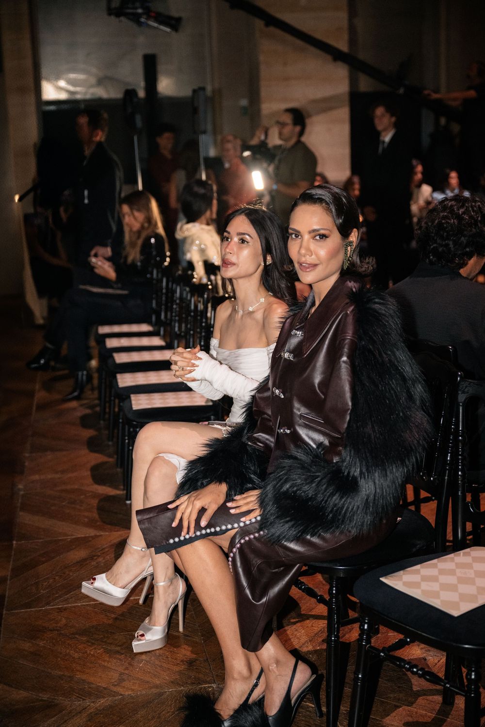 Guests seated in rows at a fashion event wearing elegant evening attire and formal wear.
