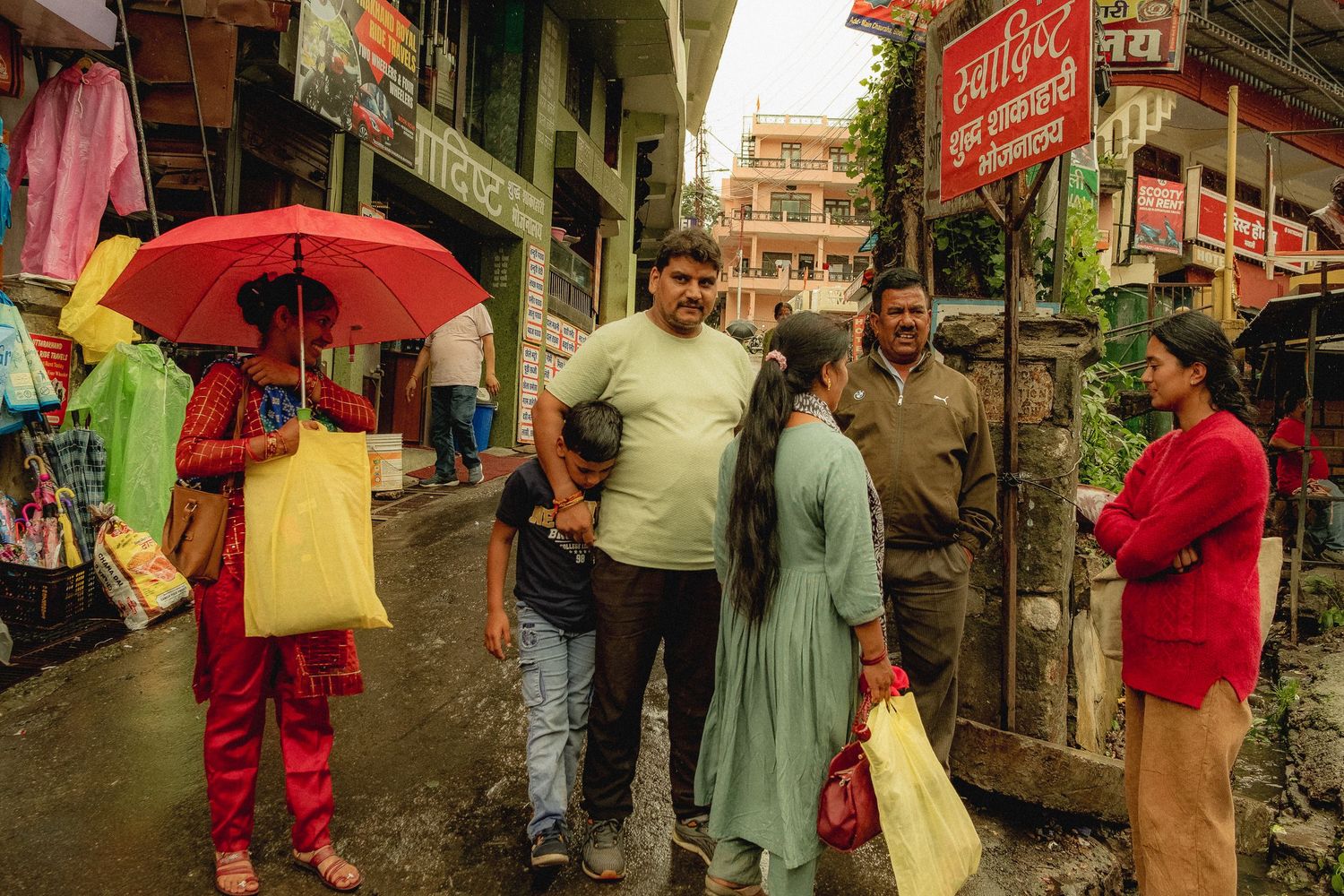 Rainy urban street scene with colorful umbrellas and street vendors.