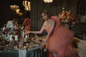 Elegant table setting with pink tulle dress by a romantic candlelit dinner with floral arrangements and vintage decor.
