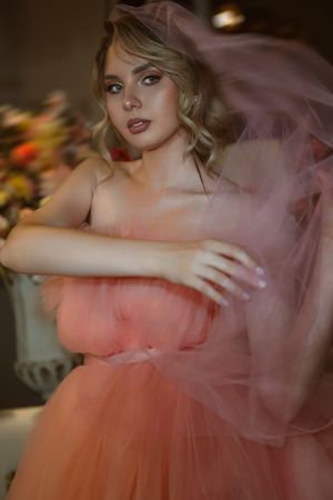 Dreamy pink tulle gown captured in soft, romantic lighting with ethereal movement.