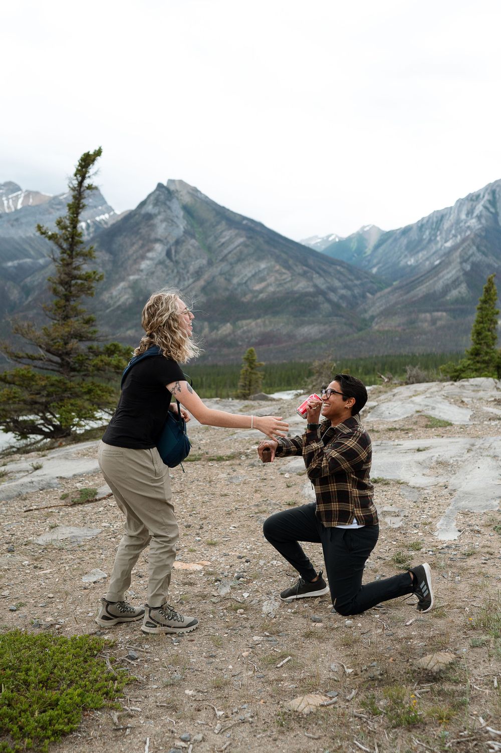 A heartfelt proposal moment captured in front of mountain range.