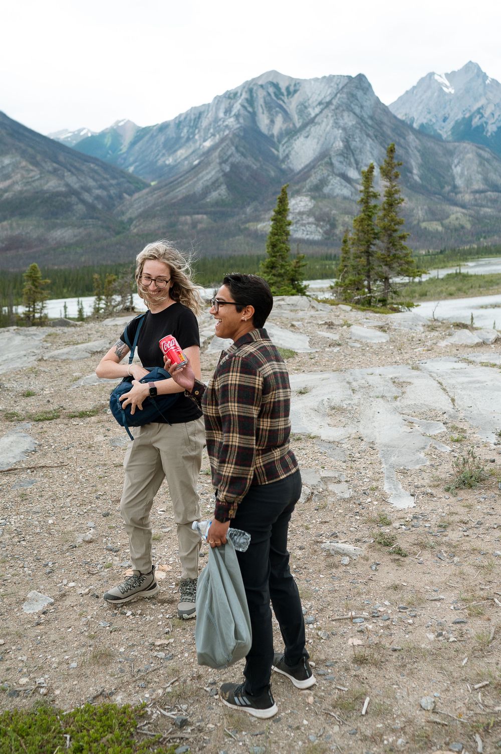 Celebrating a mountaintop proposal with mountain peaks in the background.