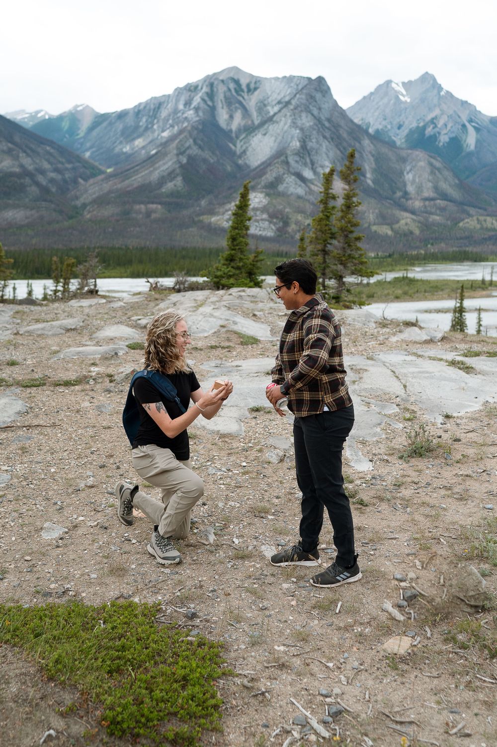 A surprise proposal moment unfolds against dramatic mountain landscape.
