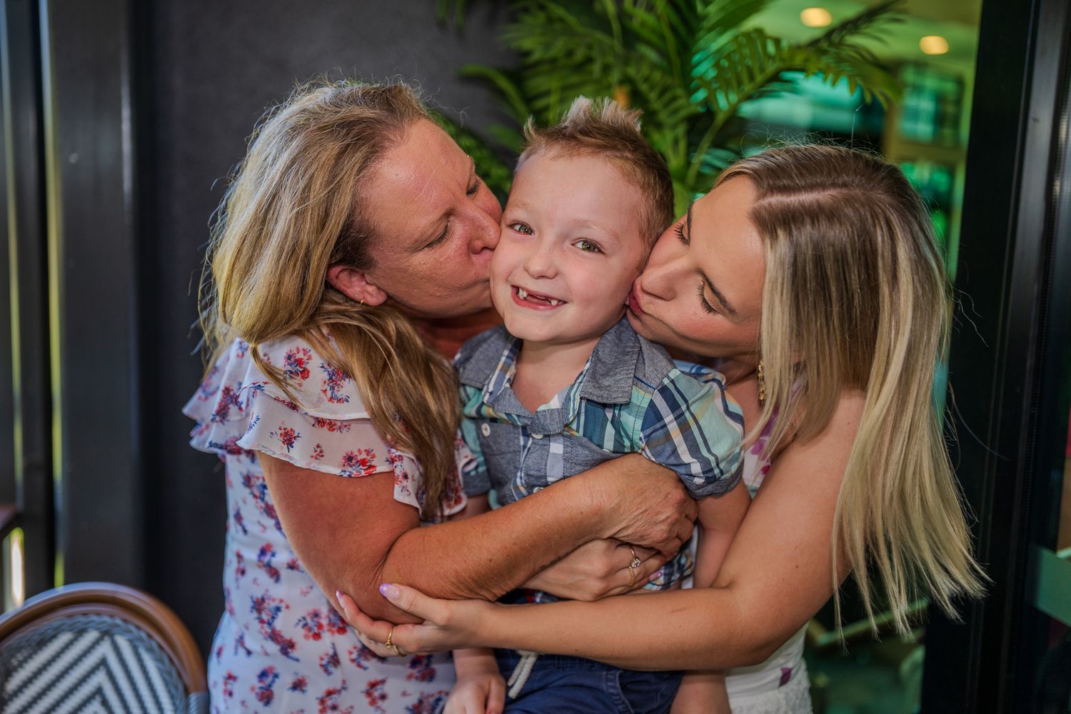 A heartwarming family moment of three people embracing and sharing laughter together.