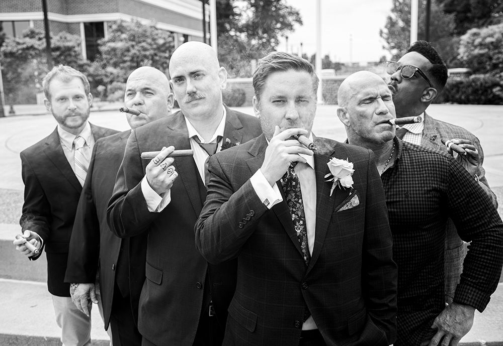 Black and white photo of groomsmen posing together with boutonnieres.