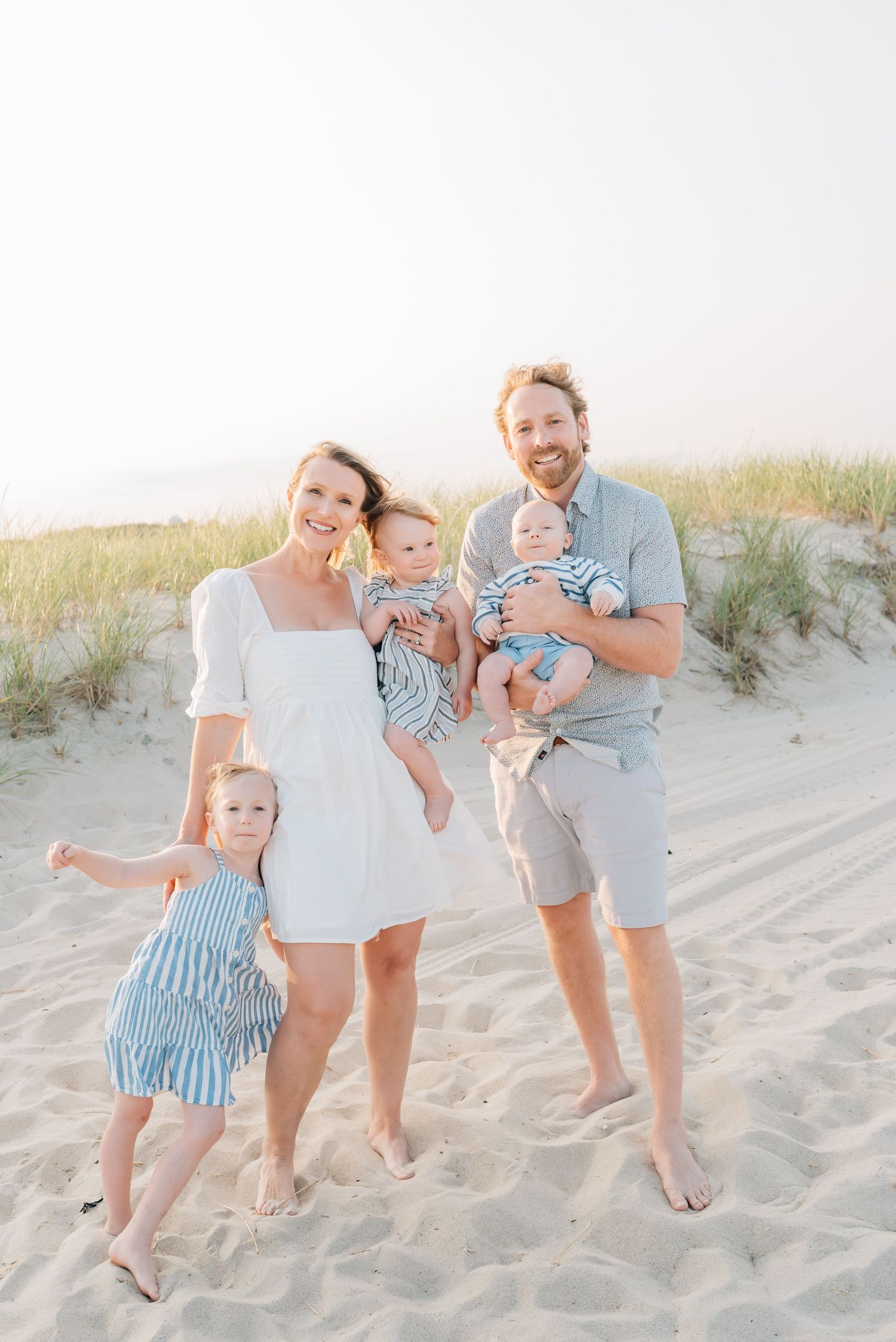 A family of five stand together on the spring lake beach in Monmouth County NJ.