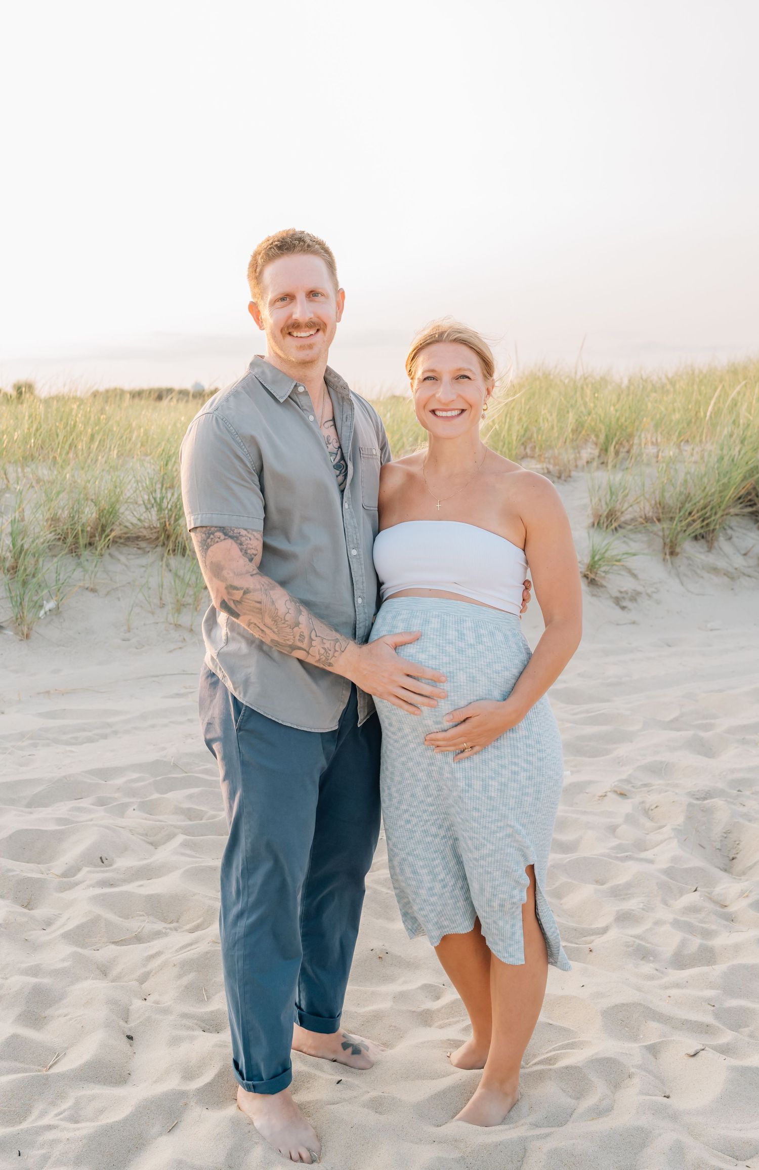 A portrait of an expecting couple on the beach in spring lake Nj.